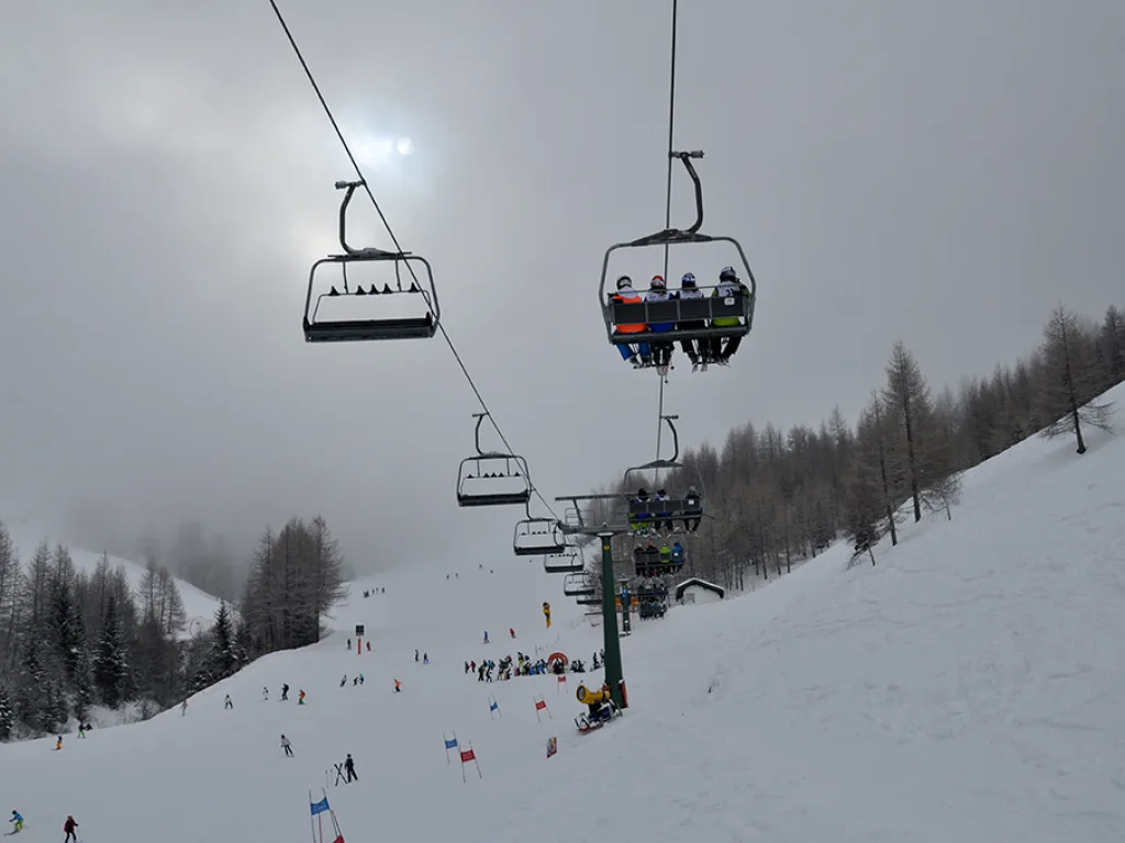 Sessellift im Nebel über der Piste.